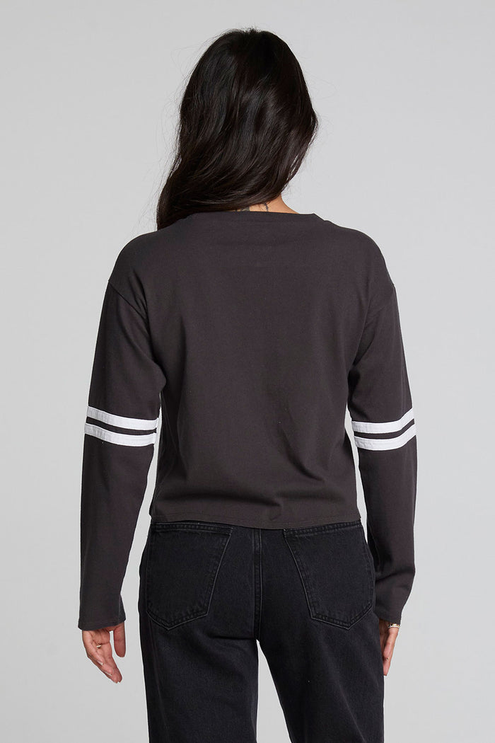 Back view of a woman wearing the Chaser 11 Long Sleeve and jeans on a neutral background