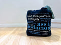 A navy tote bag with text on it, placed on a wooden floor.