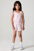 Front view of a girl wearing the Chaser Bows and Stars Shorts and white sneakers on a neutral background
