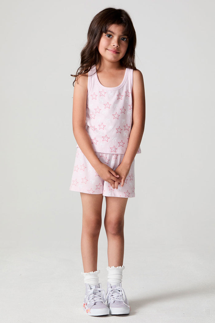 Front view of a girl wearing the Chaser Check Bow Tank and white shoes on a neutral background with arms crossed