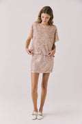 Full body view of woman wearing Chaser’s Davis Bronze Brown Tee and matching Jayde Bronze Brown Mini Skirt on a light gray background