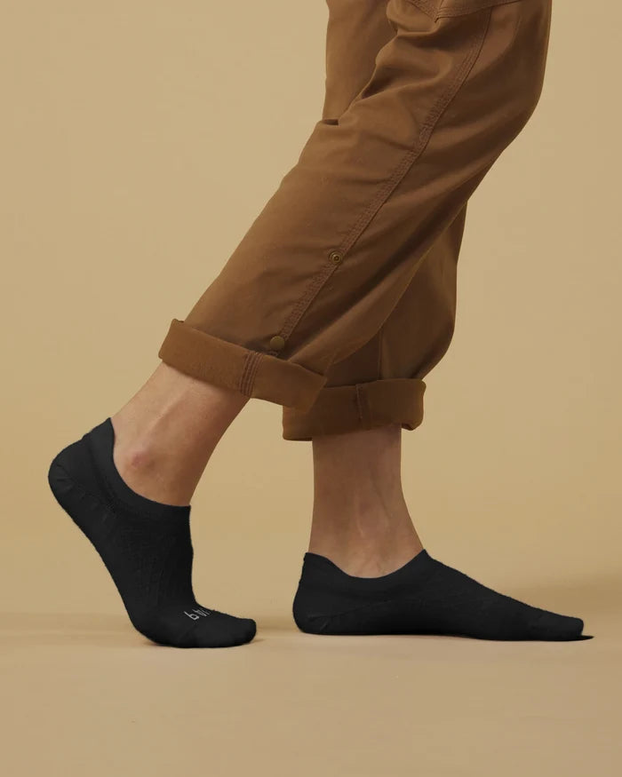 Side view of Timber Essential No Show socks on a model showing low profile, heel stay, and reinforced toe on beige background
