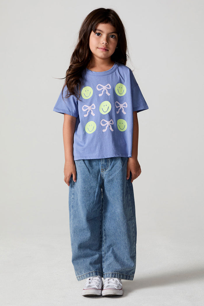 Full body front view of a girl wearing the Chaser Happy Bows Tee on a neutral background