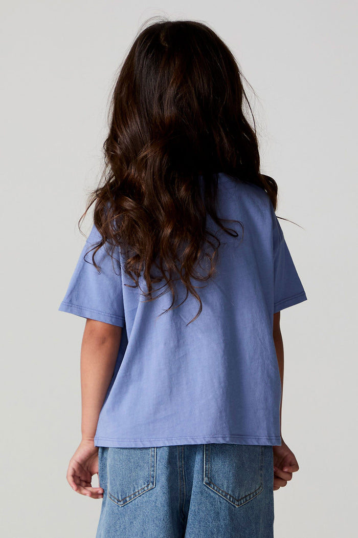 Back view of a girl wearing the Chaser Happy Bows Tee on a neutral background