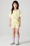 Front view of a girl wearing the Chaser Happy Happy Shorts and matching Happy Happy shorts on a neutral background with arms at her side