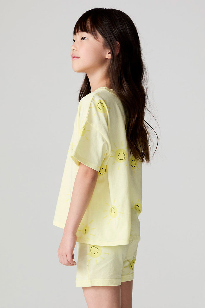 Side view of a girl wearing the Chaser Happy Happy Tee on a neutral background with matching shorts