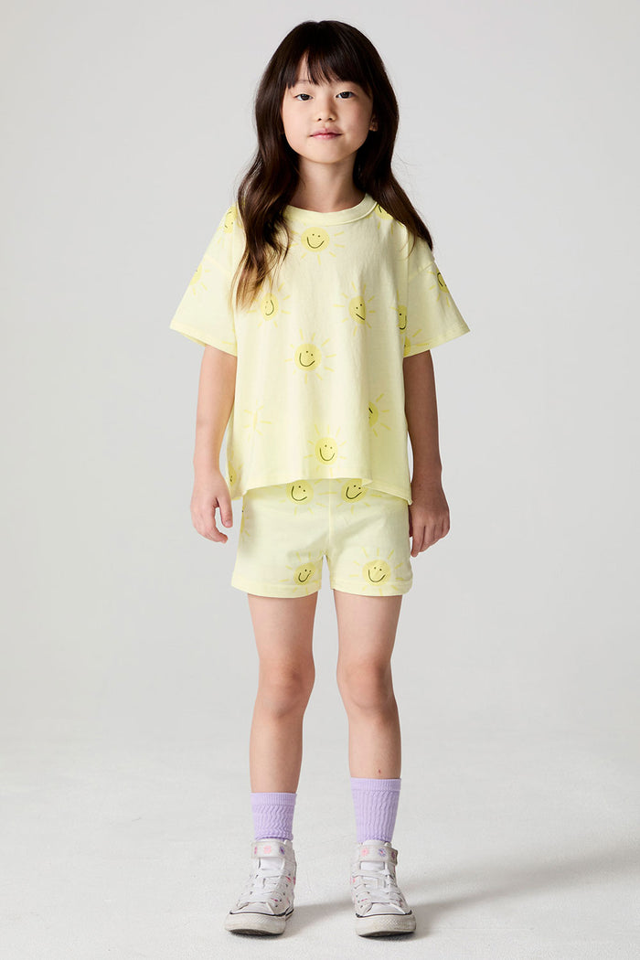 Front view of a girl wearing the Chaser Happy Happy Tee and matching yellow shorts on a neutral background