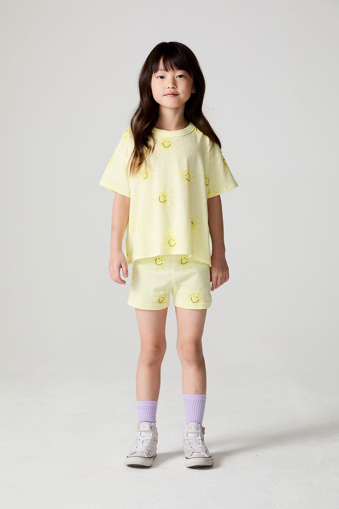 Front view of a girl wearing the Chaser Happy Happy Tee and matching shorts on a neutral background