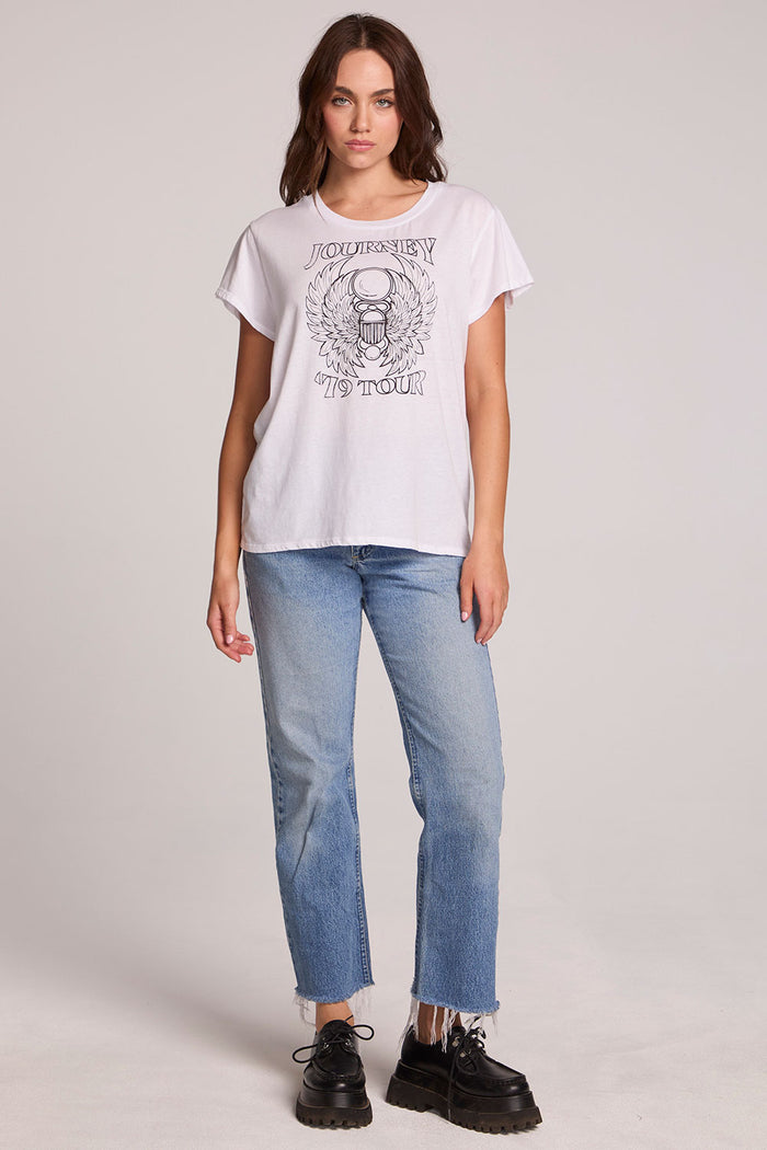 Full body view of a woman wearing the Chaser Journey 79 Tour Tee on a neutral background with blue jeans