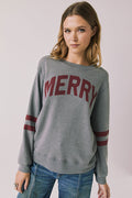 Front view of woman wearing Chaser’s Streaky Grey Merry Long Sleeve with “MERRY” printed in red and red stripes on the sleeves against a plain background