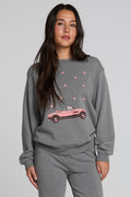 Front view of a woman wearing the Chaser  Mini Star Glaze Sweatshirt on a neutral background