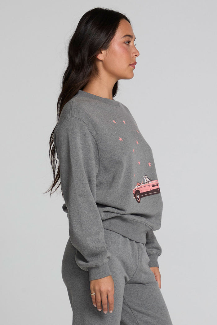 Side view of a woman wearing the Chaser  Mini Star Glaze Sweatshirt on a neutral background