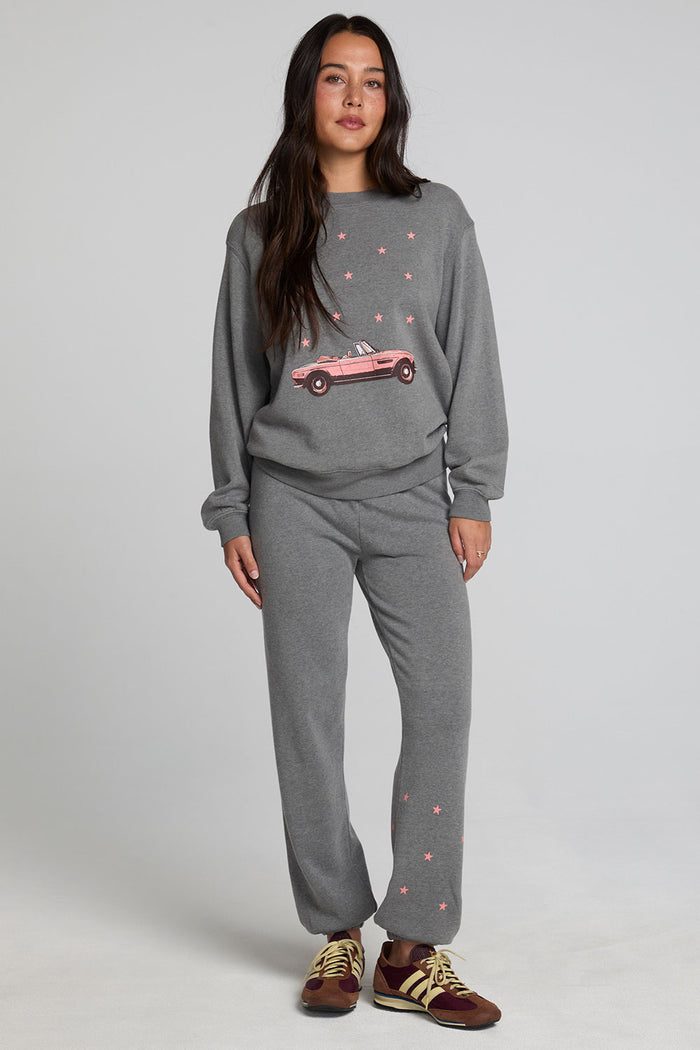 Full body front view of a woman wearing the Chaser Mini Star Glaze Sweatshirt on a neutral background in matching grey sweatpants