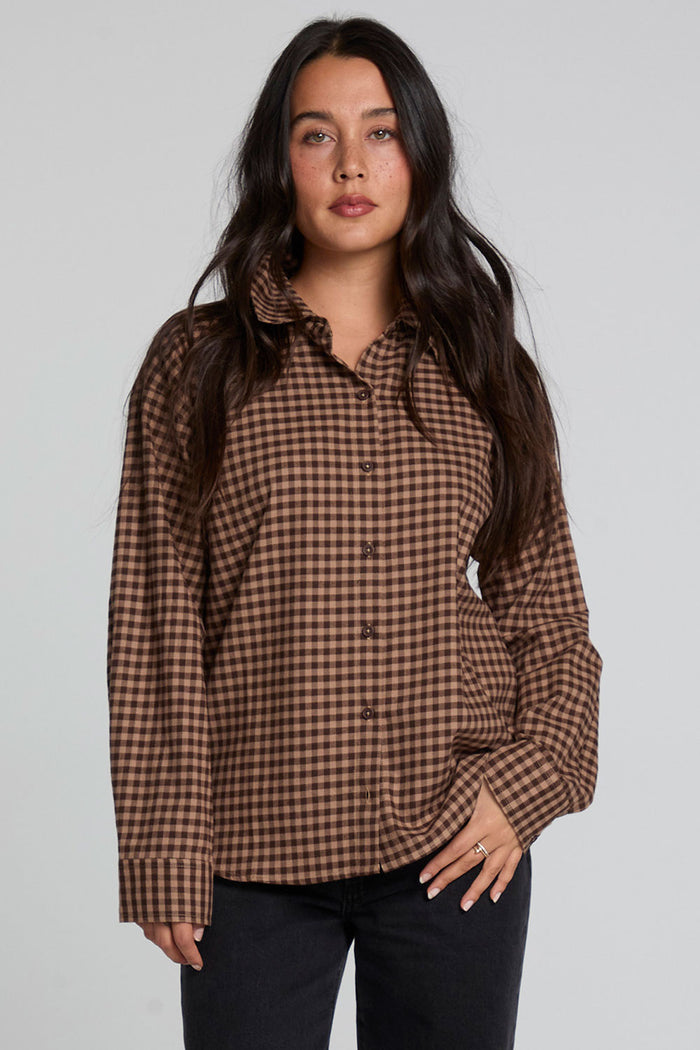 Front view of a woman wearing the Chaser Pine button down on a neutral background