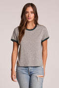 Front view of a woman wearing the Chaser  Rambler Streaky Grey and Pine Tee and jeans on a neutral background
