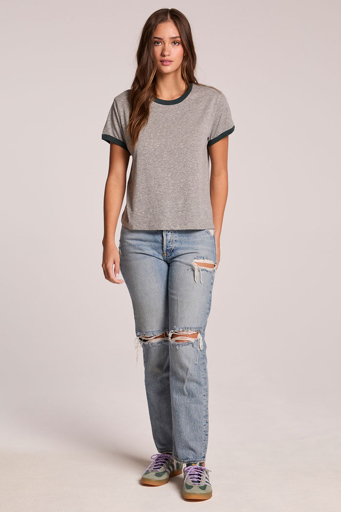 Front view of a woman wearing the Chaser  Rambler Streaky Grey and Pine Tee and sneakers on a neutral background