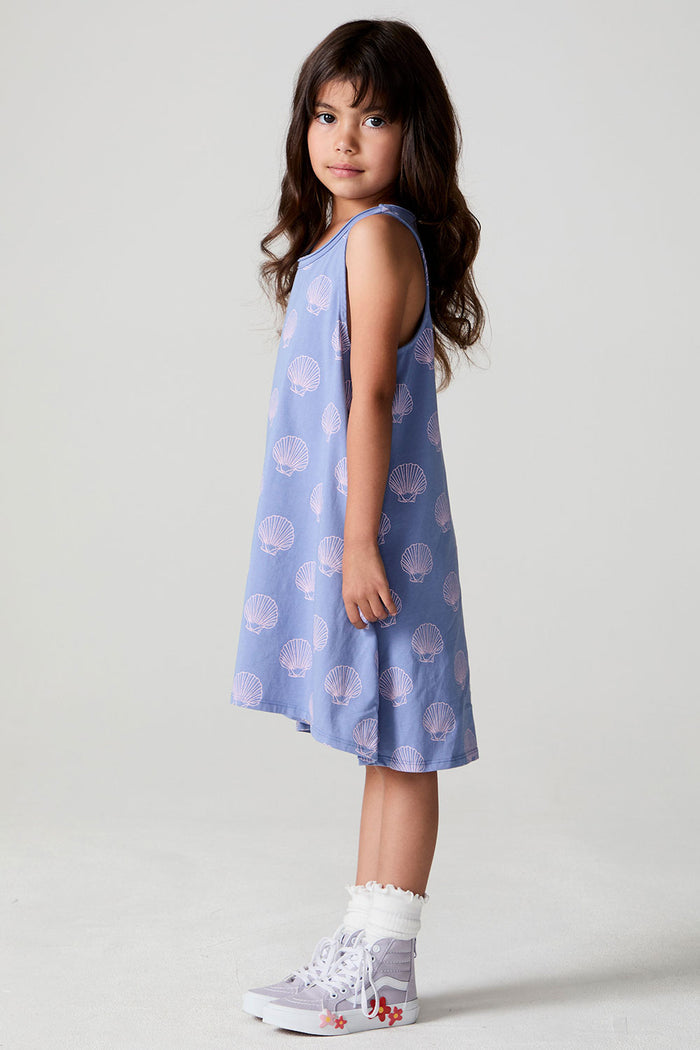 A full body side view of a girl wearing the Chaser Seashell Dreams Allover Dress and sneakers on a neutral background