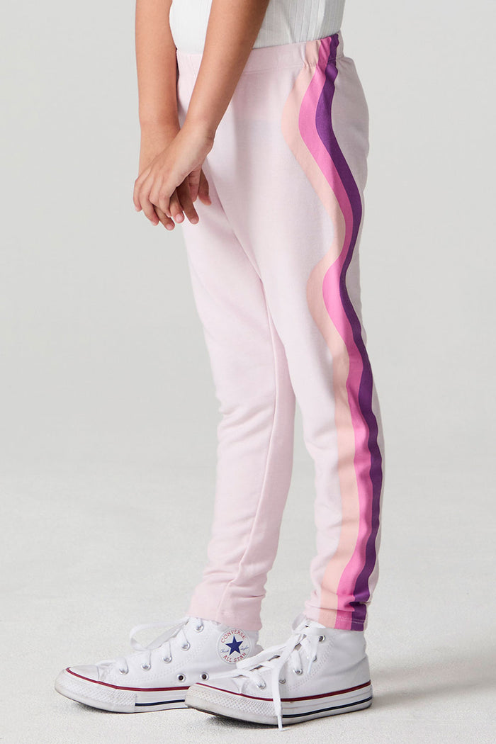 Side angle view of a girl wearing the Chaser Slim Begonia Leggings on a neutral background