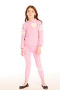 Full body view of girl wearing Chaser’s pink Slim Confetti Legging with matching Cropped Shirred Confetti Hoodie with a heart design on a white background