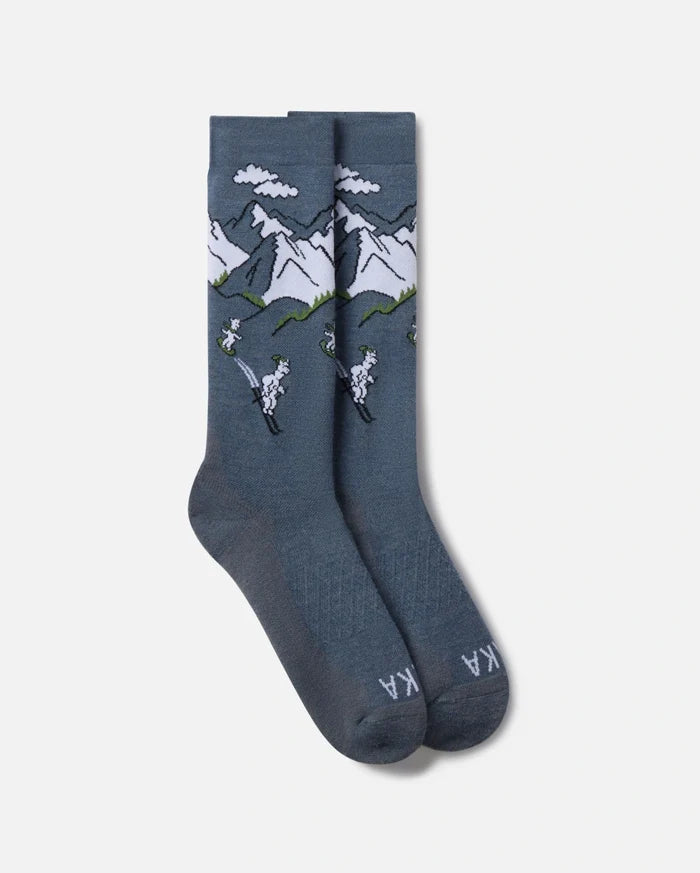 Top-down view of Snow Sebastian ski socks showcasing slate blue crew socks with mountain and skier jacquard pattern on white background