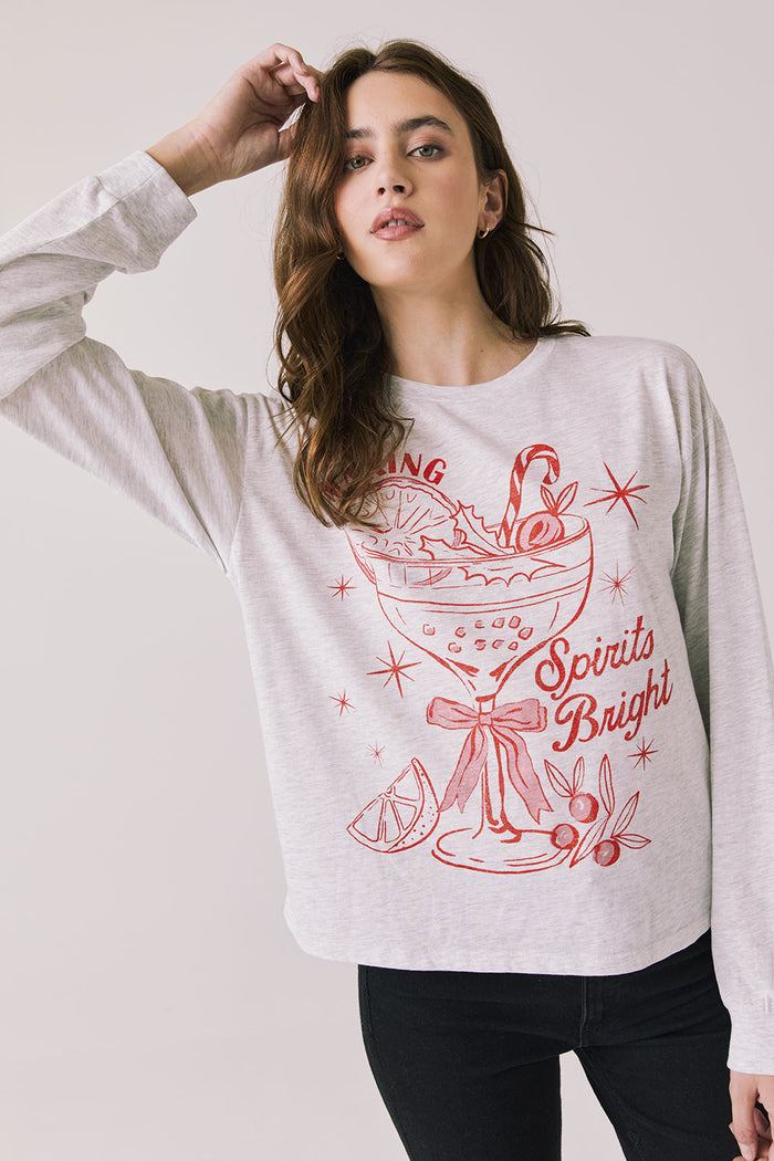 Front view of woman wearing Chaser’s Spirits Bright Light Grey Long Sleeve with red graphics and text on a light gray background