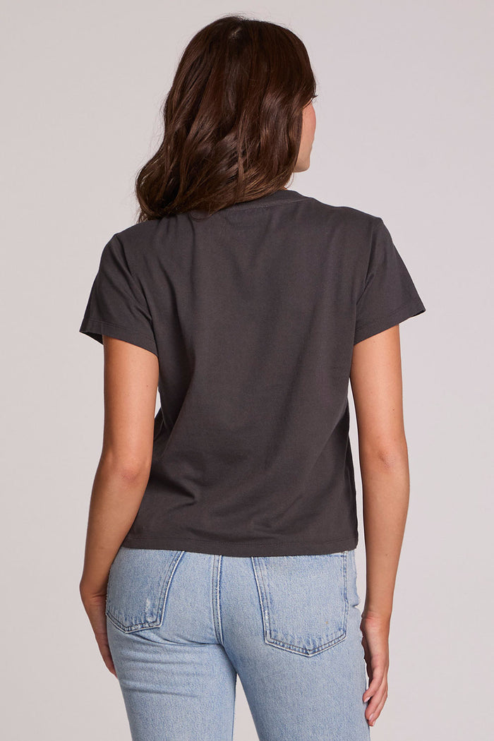 Back view of a woman wearing the Chaser Sun Records Tee on a neutral background with arms at her sides