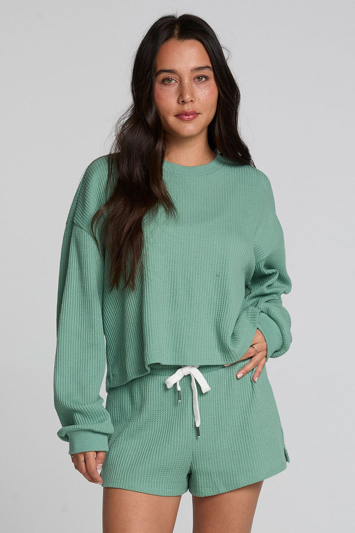 Front view of a woman wearing the Chaser  Suzzans Verdelle Sweatshirt on a neutral background