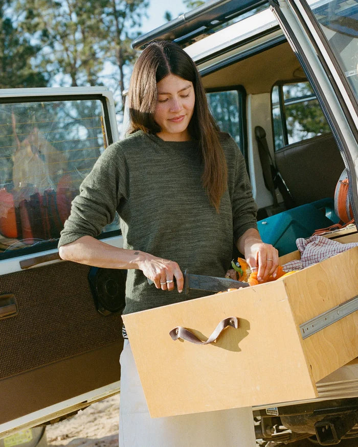 Three-quarter view of The Hoodie alpaca wool hoodie in eucalyptus on a model showing regular fit at an open vehicle tailgate