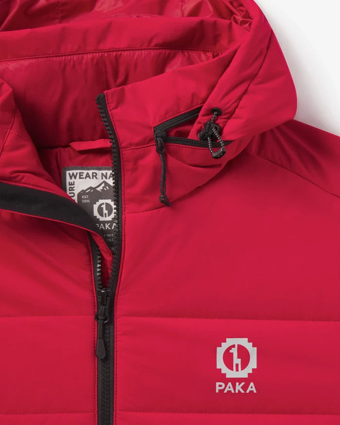 Close-up of The Huascarán Jacket showing red hood, front zipper, horizontal quilting and PAKA logo on white background
