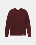 Front view of The Lightweight Crew sweater in burgundy with V-stitch at collar, cuffs and logo patch on gray background