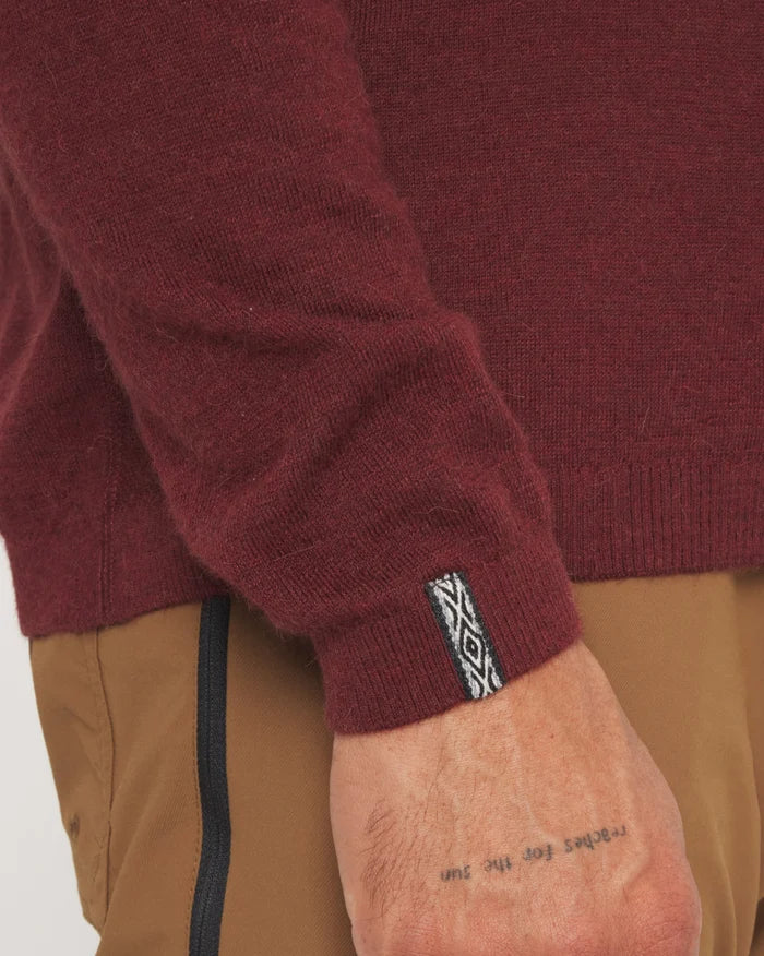 Close-up sleeve view of The Lightweight Crew in burgundy showcasing ribbed cuff and woven brand tab on white background