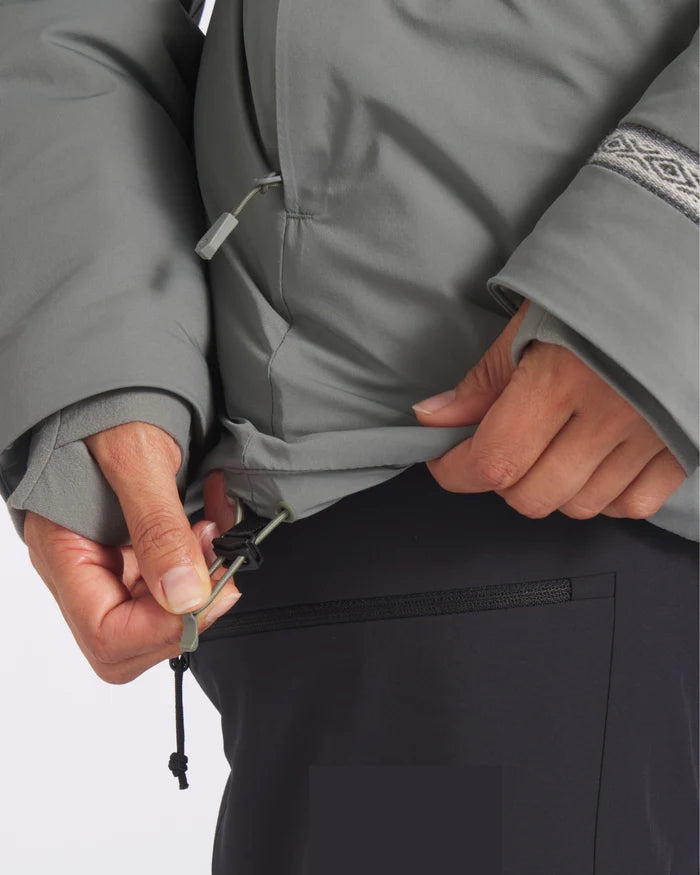 Close-up of women’s Apu Parka showing hem drawcord adjustment and thumbhole cuff on grey jacket against white background