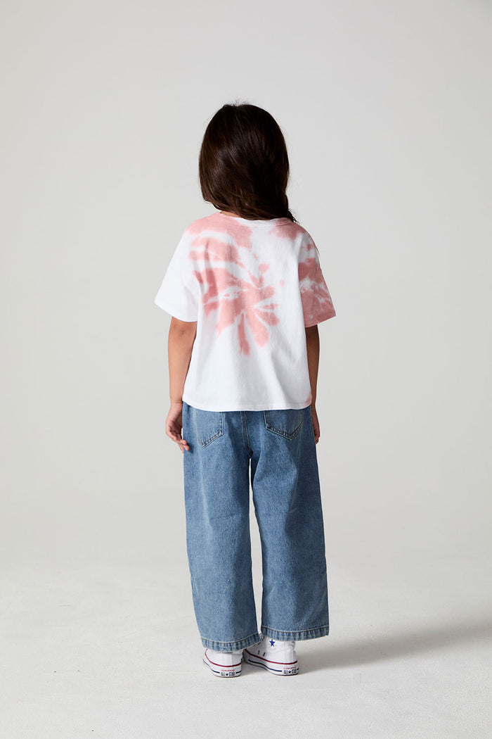A full body back view of a girl wearing the Chaser The Rolling Stones Americana Stones Tee on a neutral background