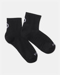 Flat lay of Trail 1/4 crew socks in black showcasing white PAKA logo and ribbed cushioned footbed on a light gray background