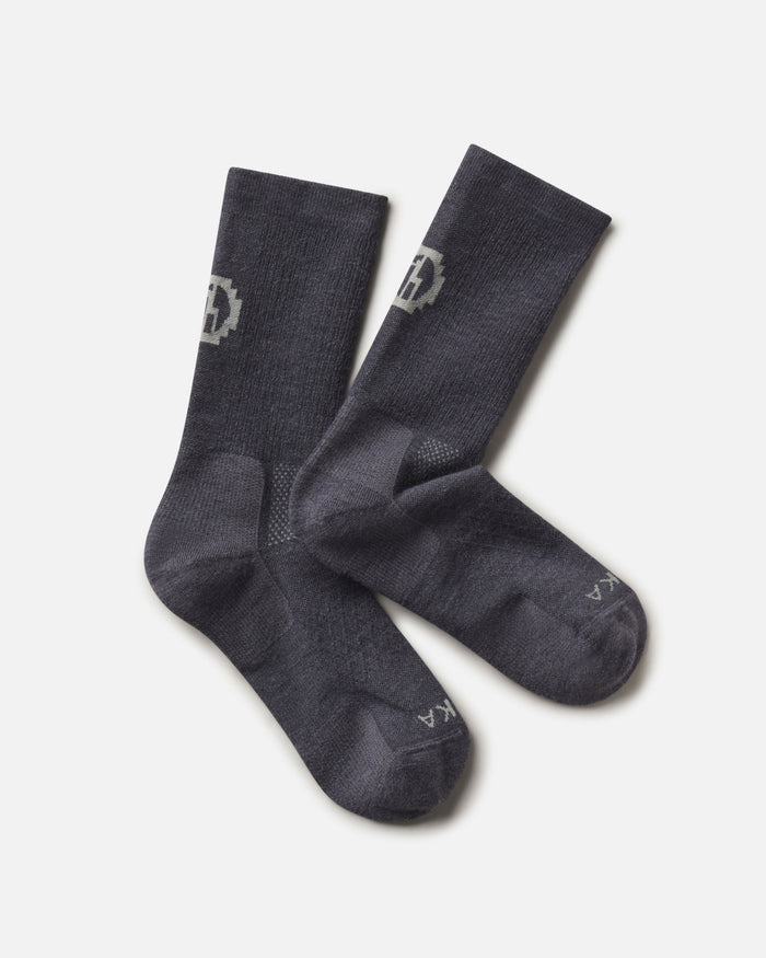 Top-down view of Trail Crew Socks showcasing charcoal blue color, crew height, cushioned footbed and PAKA logo on white background