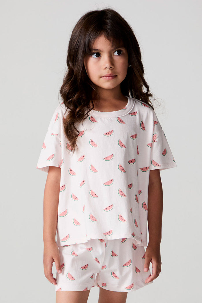 Front view of a girl wearing the Chaser Watermelon All Over Tee on a neutral background with arms at sides