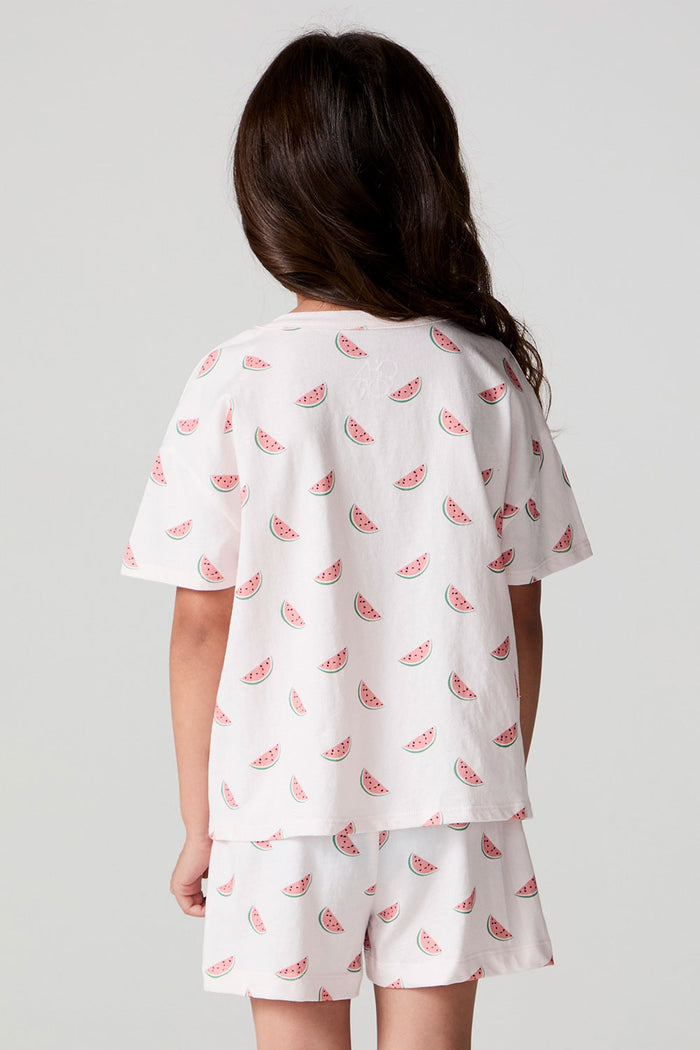 Back view of a girl wearing the Chaser Watermelon All Over Tee on a neutral background