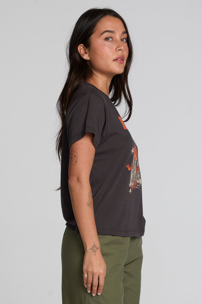 Side view of a woman wearing the Chaser  Wild And Free Cropped Graphic Tee on a neutral background