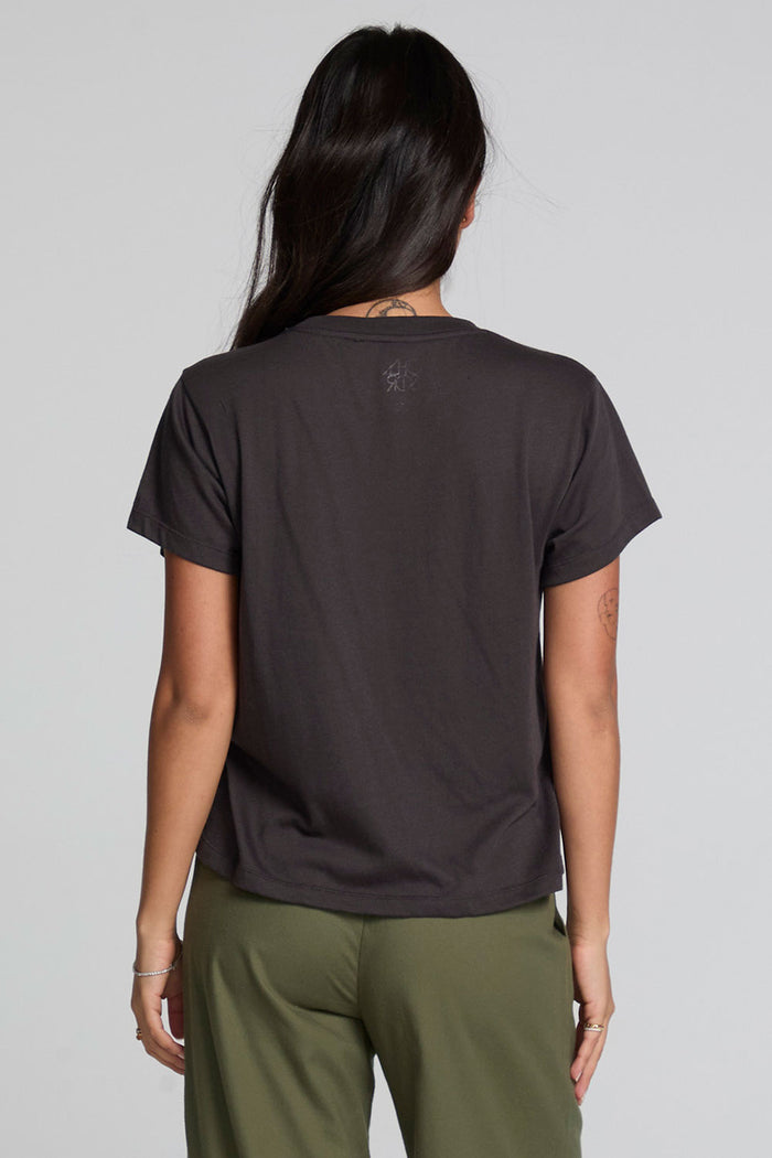 Back view of a woman wearing the Chaser  Wild And Free Cropped Graphic Tee on a neutral background