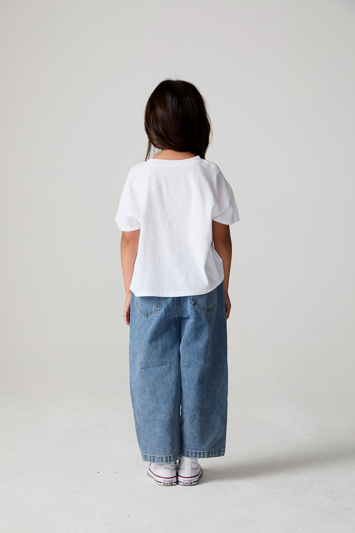 Full body back view of a girl wearing the Chaser Willie Nelson Cowgirl Tee on a neutral background