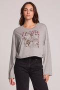 Front view of a woman wearing the Chaser Willie Nelson Horseback Long Sleeve on a neutral background with arms at sides and black pants