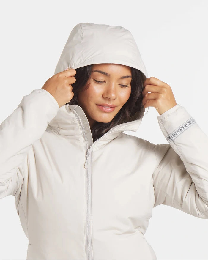 Front close-up of Women’s Apu Lightweight Puffer showing hood, full zipper, patterned cuff, plain light background