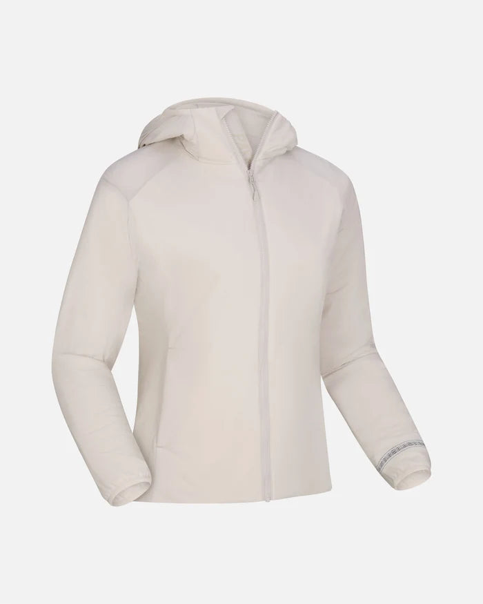 Angled view of Women’s Apu Lightweight Puffer jacket with hood, full zip, and side pockets on light gray background