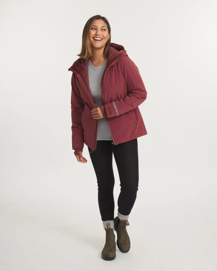 Three-quarter view of Women’s Apu Parka, Burgundy, hooded insulated ski jacket with hip-length fit on model, white background
