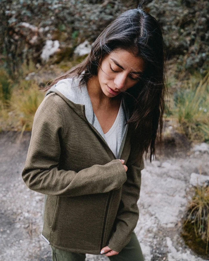 Three-quarter view of Women’s Breathe zip alpaca hoodie in Andean Moss, showing zip and gray hood lining, on outdoor trail