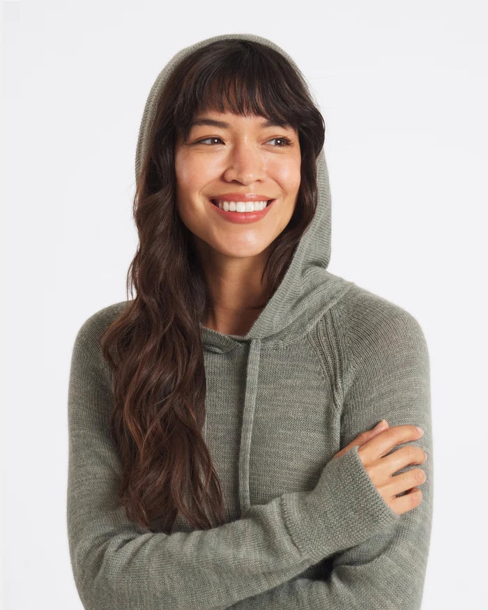 Three-quarter view of women’s alpaca hoodie showing hood, raglan sleeves, thumbhole cuffs, lightweight knit in sage green on white