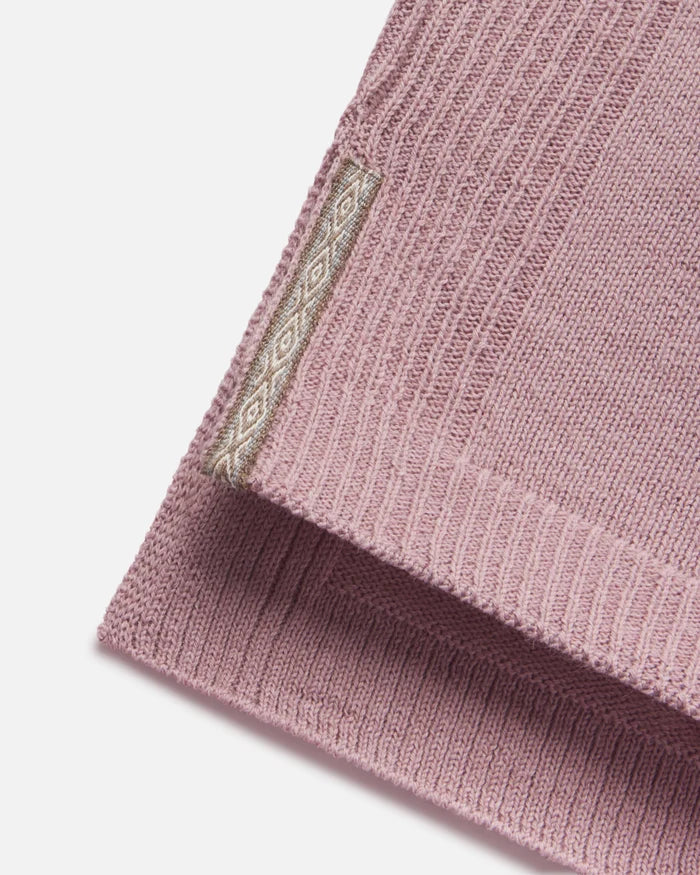 Close-up of women’s alpaca hoodie hem showcasing ribbed knit texture and woven PAKA tag on a white background