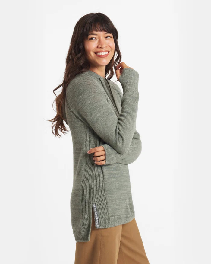 Side view of women’s alpaca hoodie in sage green on model showing ribbed side panels and side slit