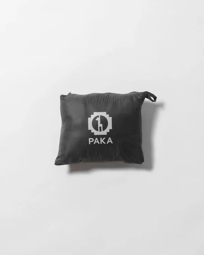 Front view of Women’s Mayu Ultralight Jacket packed into its black PAKA pouch on white background